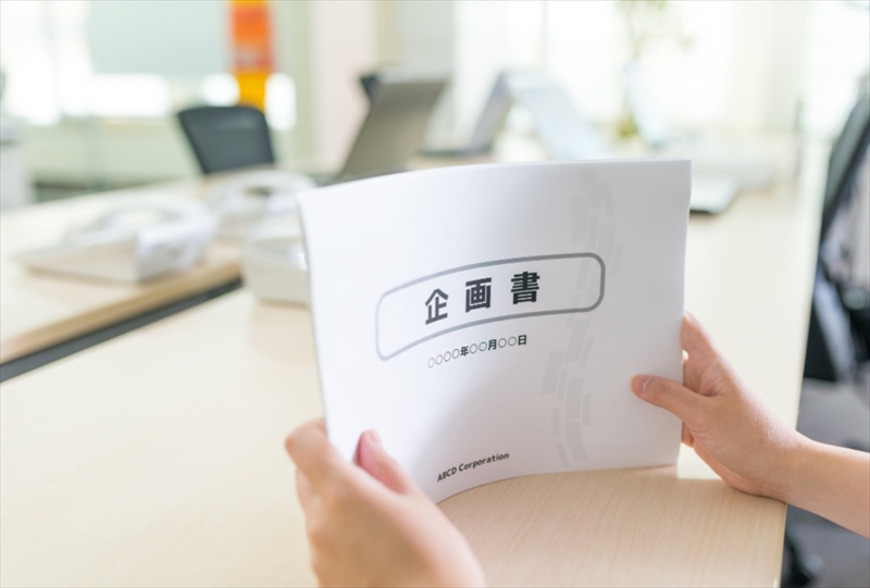 企画書を持つ手